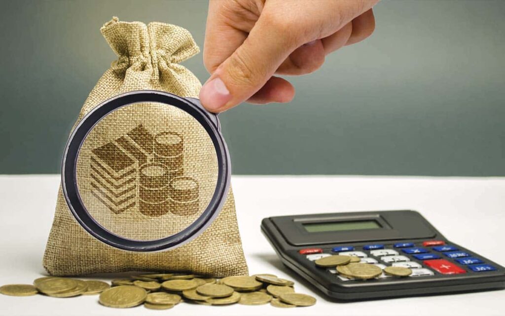 imagem de uma lupa sobre um saco de dinheiro